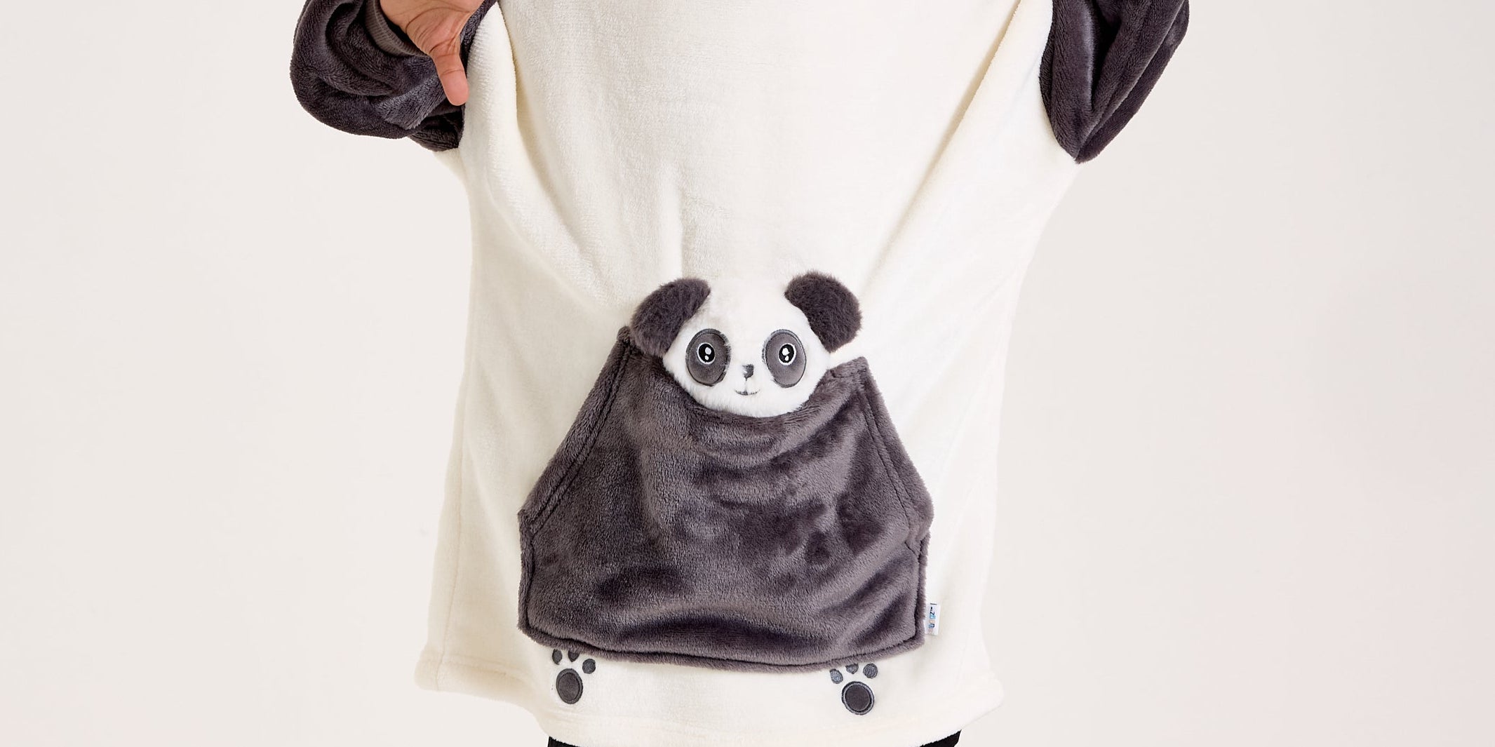 Child wearing a panda-themed poncho with a hood on a white background