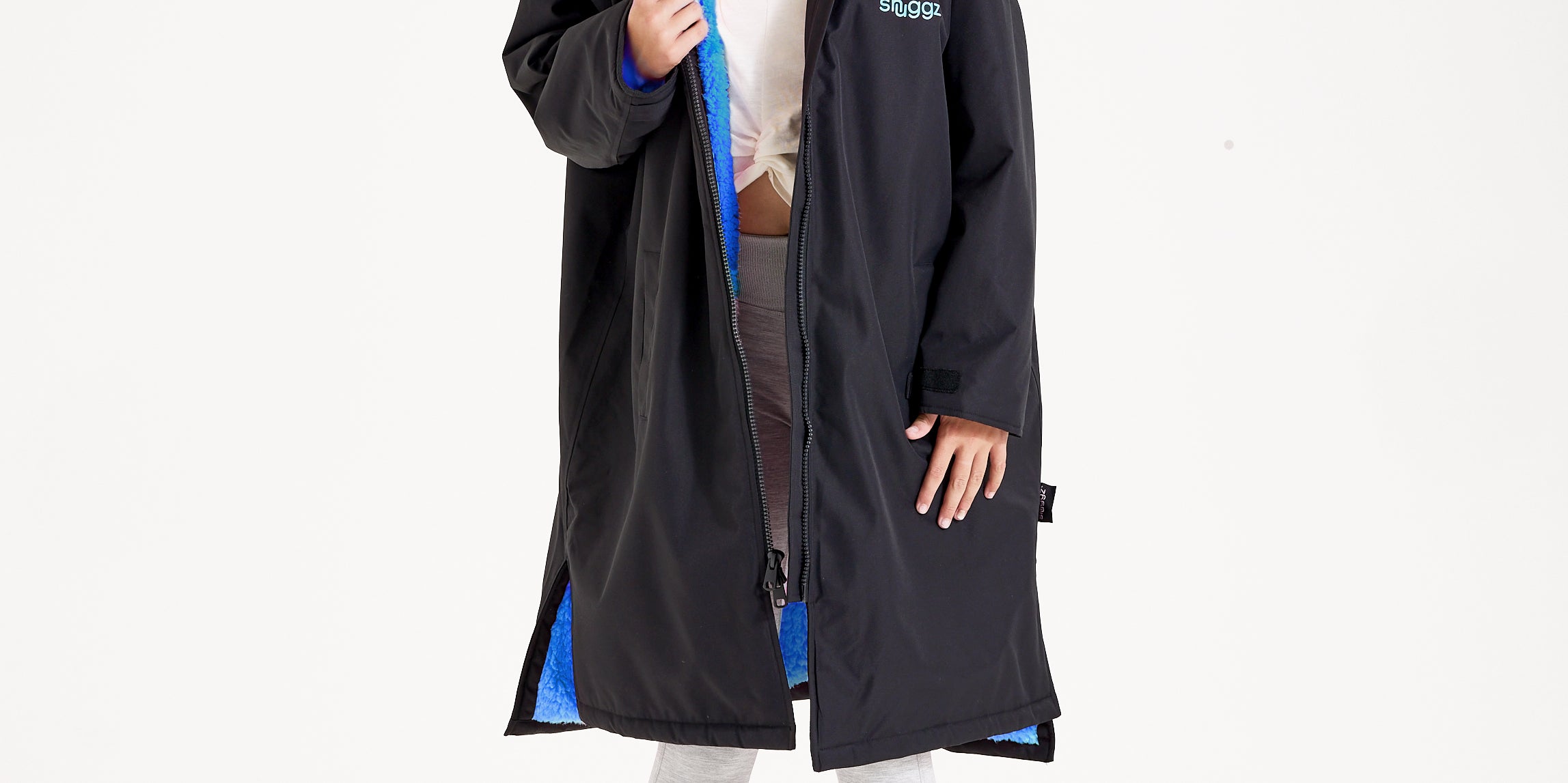 Girl wearing the Snuggz kids black changing robe with blue borg lining